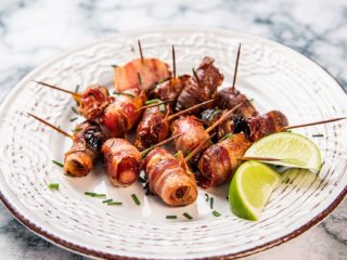 Cocktail-sausages and dried prunes wrapped in bacon