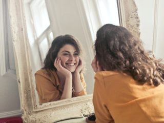 Woman smiling in her mirror